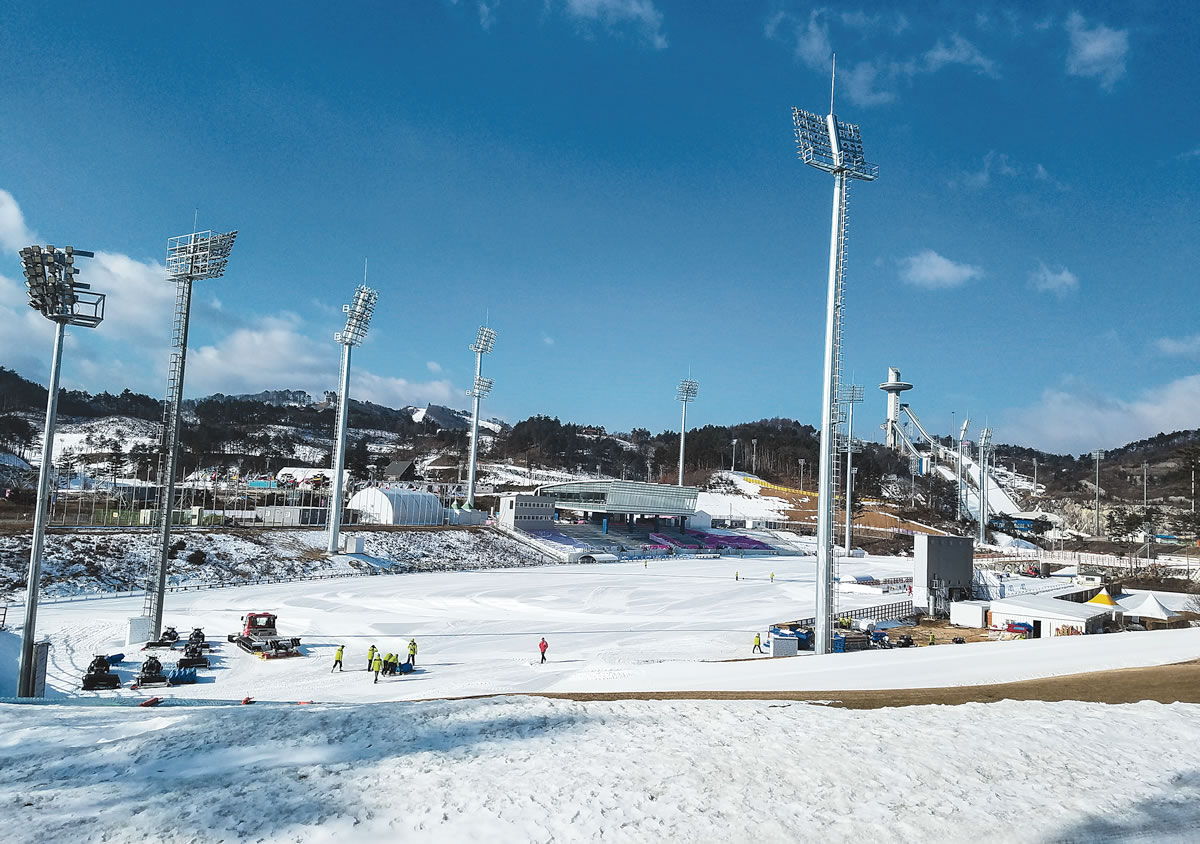 Moving snow and laying tracks. Officials prep the venue before a World Cup test event. [Photo] Jason Kask